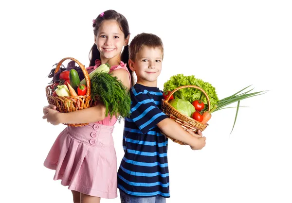 Crianças sorridentes com legumes na cesta — Fotografia de Stock
