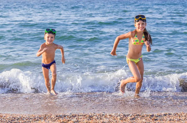 Happy kids runs from the sea — Stock Photo, Image