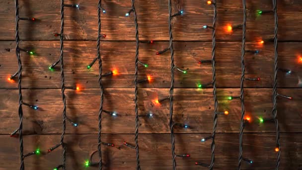 Тёмный праздничный деревянный фон с электрической гирляндой — стоковое видео