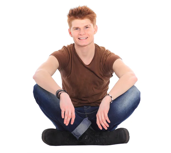 Pensive stylish young man sitting on floor and looking at copysp — Stockfoto