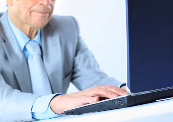 O homem de negócios na idade de trabalha para o computador portátil. Isolado sobre um fundo branco . — Fotografia de Stock