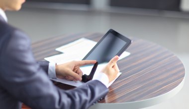 İş yerindeki modern dijital tablet bilgisayarına elle dokunmak.