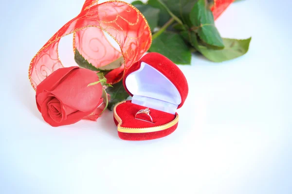 Une rose et une boîte avec des anneaux — Photo