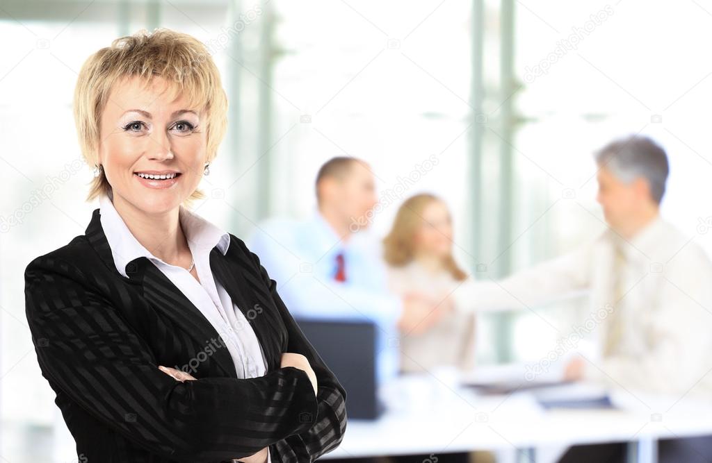 confident business woman with team behind her