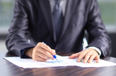 Ofiste belgelerle çalışan bir işadamı.