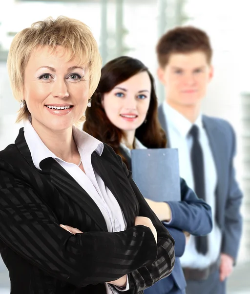 Vertrouwen zakenvrouw met team achter haar — Stockfoto