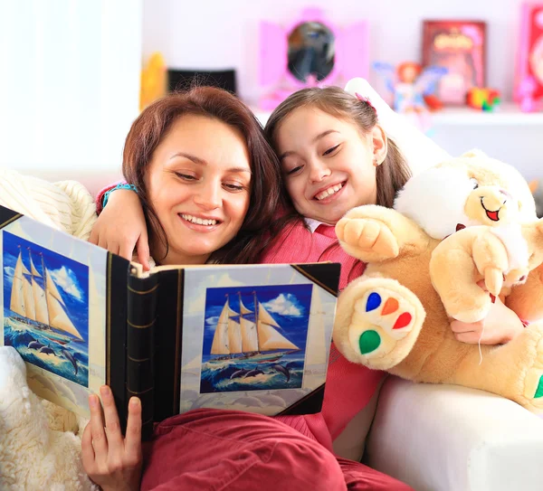 Felice madre e figlia leggendo un libro insieme — Foto Stock