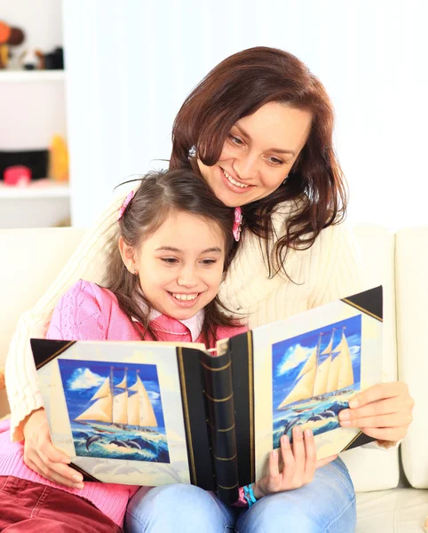 Lycklig mor och dotter läser en bok tillsammans — Stockfoto