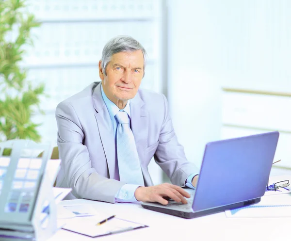 The businessman at the age of works for the laptop. — Stock Photo, Image