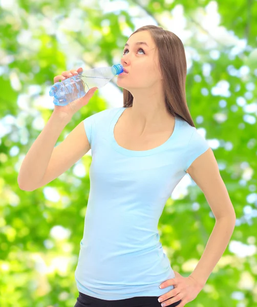 Sport meisje drinkwater op de straat. — Stockfoto