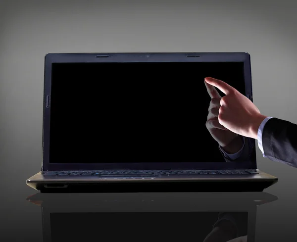 Close-up of male hand with forefinger pointing at laptop screen over black background — Stock Photo, Image