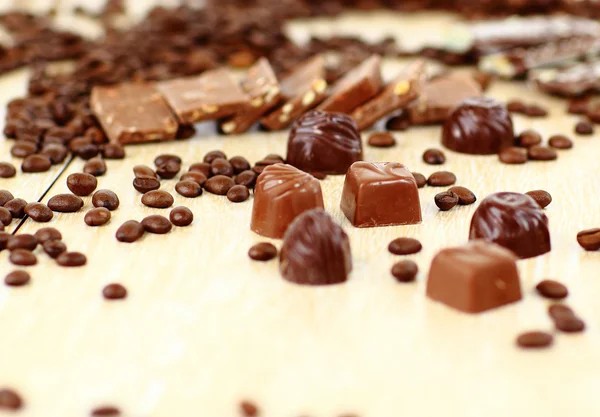 Dolci caramelle al cioccolato e chicchi di caffè isolati su sfondo bianco — Foto Stock