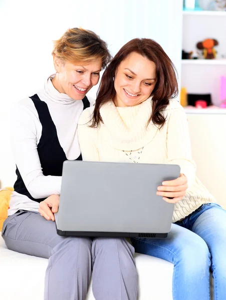 Ein schönes Mädchen mit einem Laptop zu Hause. — Stockfoto