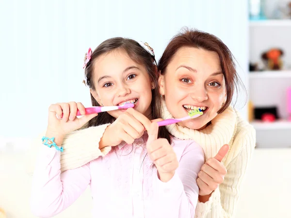Anne ve kızı dişlerini fırça. — Stok fotoğraf