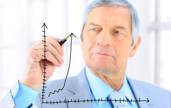 Businessman in age, draws a graph. Isolated on a white background. — Stock Photo, Image