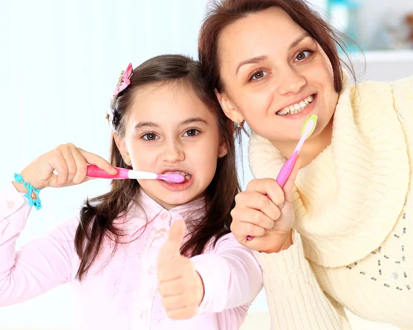 Madre e hija se cepillan los dientes . — Foto de Stock