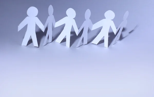 Team of paper doll holding hands — Stock Photo, Image