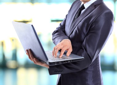 Dizüstü bilgisayarı olan iş adamı.