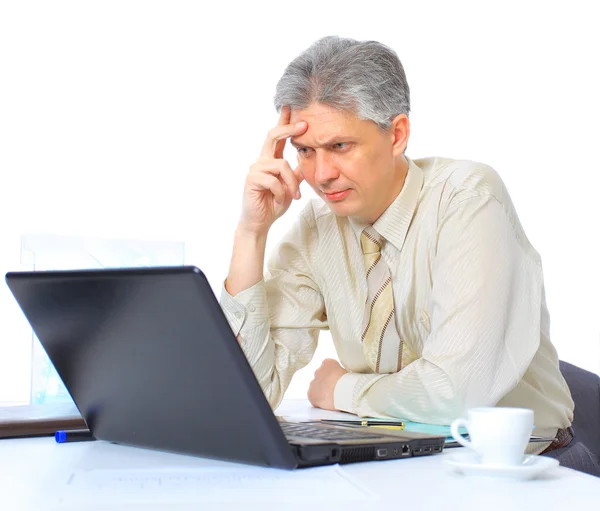 El empresario a la edad de los trabajos para el portátil. Aislado sobre un fondo blanco . —  Fotos de Stock