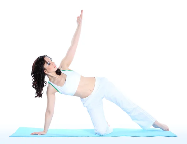 Mujer joven en postura de yoga sobre fondo blanco aislado — Foto de Stock