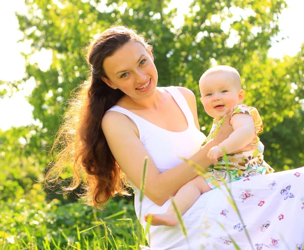 Schöne Mutter und Baby im Freien. Natur. Schöne Mutter und ihr Kind spielen gemeinsam im Park — Stockfoto