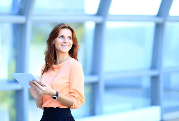 Zakenvrouw werken aan digitale tablet outdoor over gebouw achtergrond — Stockfoto