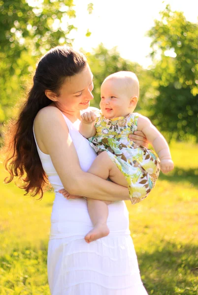 Schöne Mutter und Baby im Freien. Natur. Schöne Mutter und ihr Kind spielen gemeinsam im Park — Stockfoto