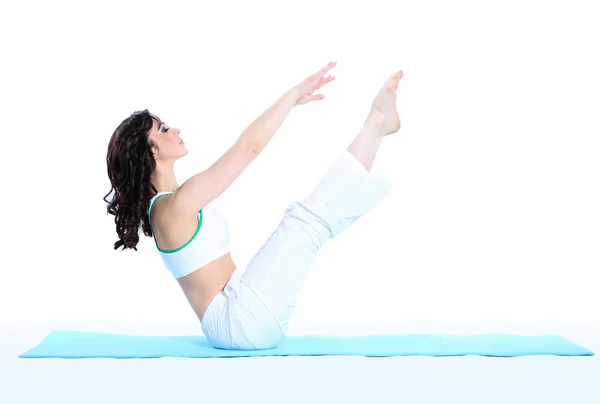 Jeune femme en pose de yoga sur fond blanc isolé — Photo