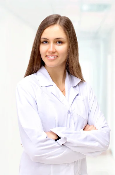 Portrait of happy young doctor woman standing with arms crossed. Royalty Free Stock Images