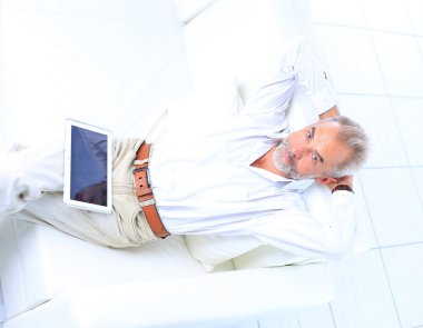 çalışma ve bir tablet kullanarak üst düzey iş adamı