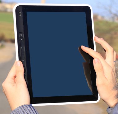 Bir tablet tutan kadın elleri izole ekranlı bilgisayar aygıtına dokunuyor.