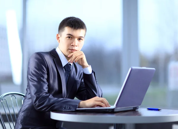 Person tippt in einem Büro auf einem modernen Laptop — Stockfoto