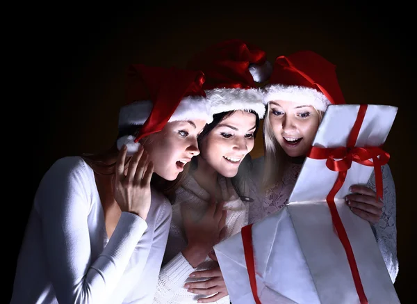 Girls with a new year gift on a dark background — Stock Photo, Image