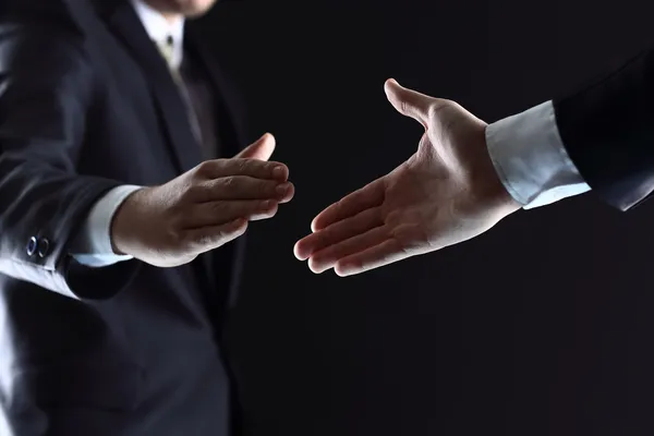 Empresários apertando as mãos, terminando uma reunião — Fotografia de Stock