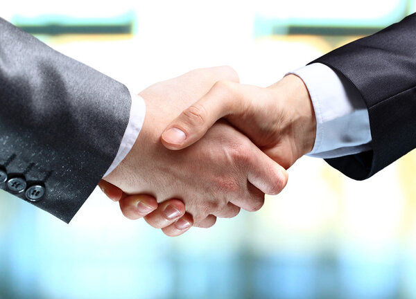Close-up of business people shaking hands to confirm their partnership