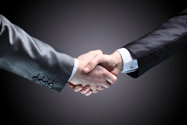 Close-up of business people shaking hands to confirm their partnership — Stock Photo, Image