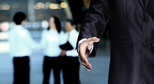 Oferta de hombre de negocios para apretón de manos en los edificios de oficinas de fondo —  Fotos de Stock