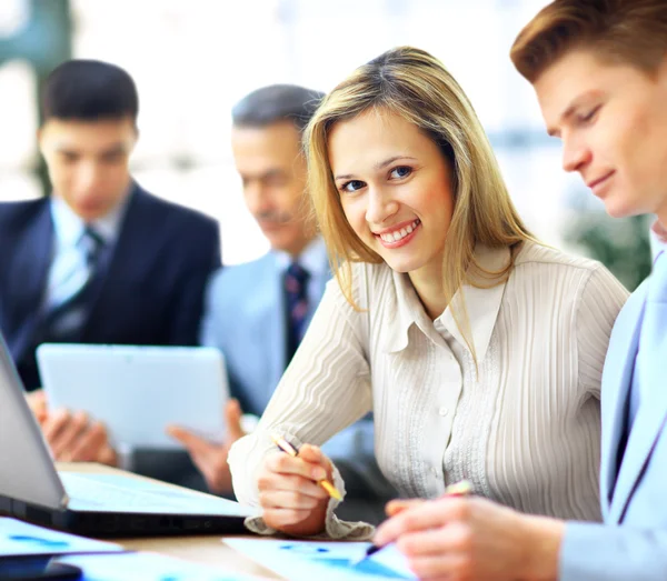 Sorrindo empresária posando enquanto colegas conversando juntos no escritório brilhante — Fotografia de Stock