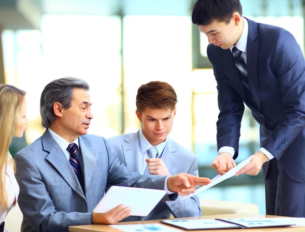 Business-Team interviewt jungen Bewerber im hellen Büro — Stockfoto