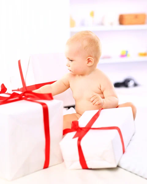 Adorable petite fille avec des boîtes-cadeaux posant sur le canapé — Photo