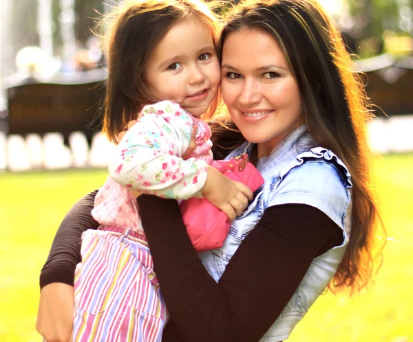 Smiling mother and little daughter on nature. Happy people outdoors — Stock Photo, Image