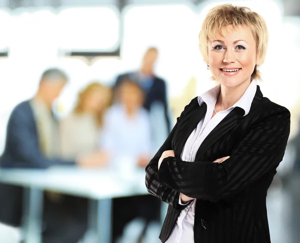 Erfolgreiche Geschäftsfrau sieht selbstbewusst und lächelnd aus — Stockfoto