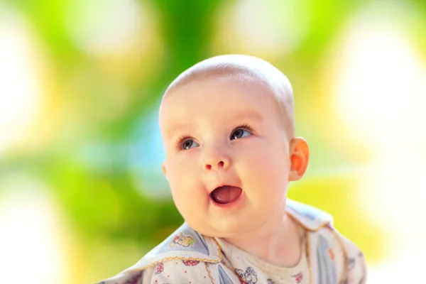 Baby sitting on green grass — Stock Photo, Image