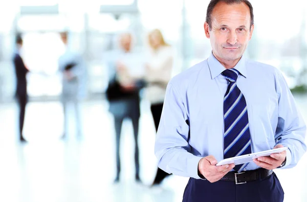 Handsome businessman using tablet computer in modern office — Stock Photo, Image