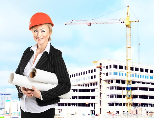 Jeune femme spécialiste de la construction examinant les plans sur le chantier de construction — Photo