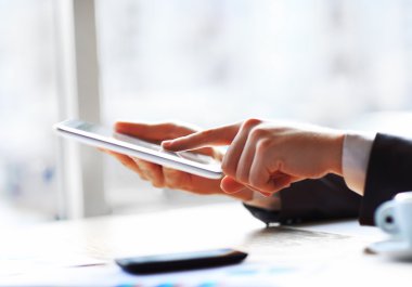 İş yerindeki modern dijital tablet bilgisayarına elle dokunmak.