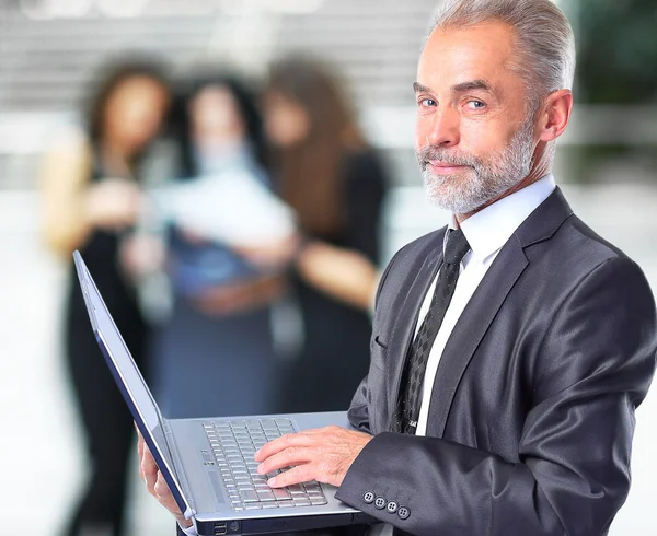 Happy smart business man with team mates discussing in the background — Stock Photo, Image