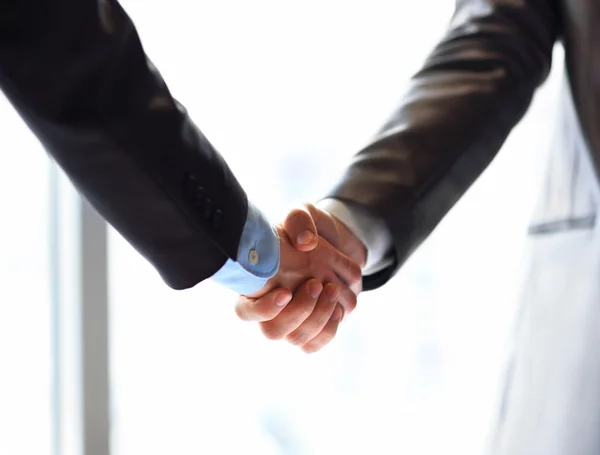 Close-up of business people shaking hands to confirm their partnership