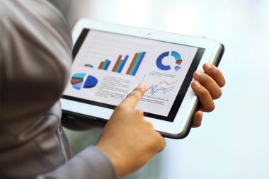Finansal verilerle çalışmak için tablet bilgisayarınızı kullanarak iş kadını Close-Up