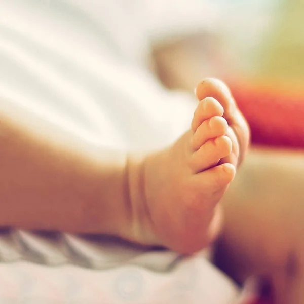 Close-up van de benen van een pasgeboren baby liggend op een deken — Stockfoto